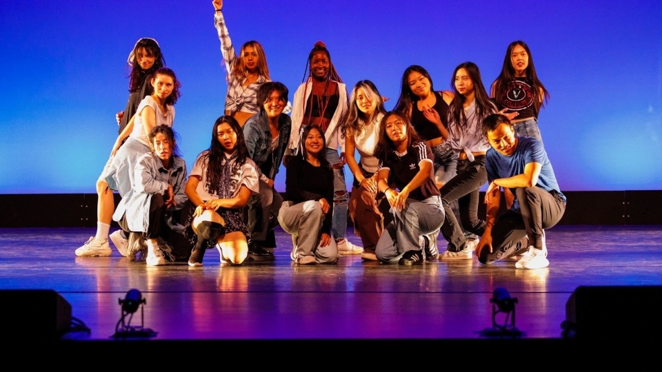 a group of students pose together after a dance performance on stage