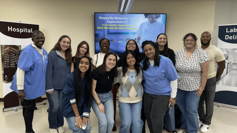a group of students and adults in scrubs standing together and smiling