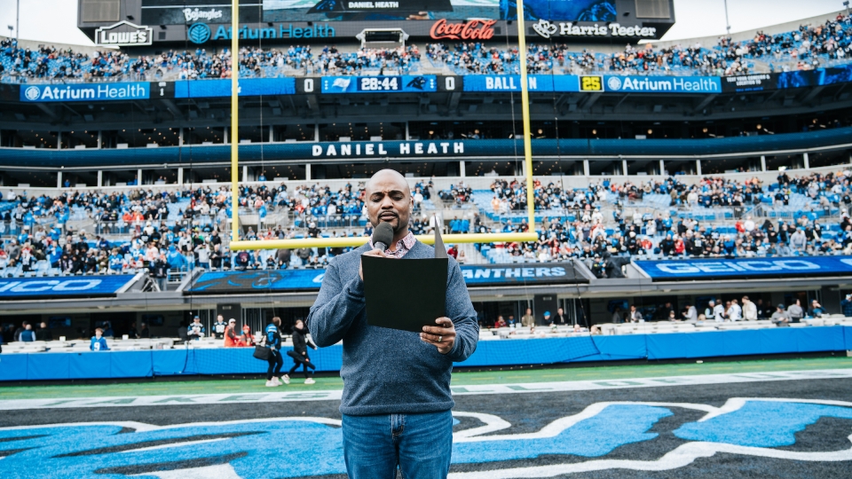 Daniel Heath reading to the crowd as the inaugural chaplain for Charlotte Football Club (Charlotte FC),