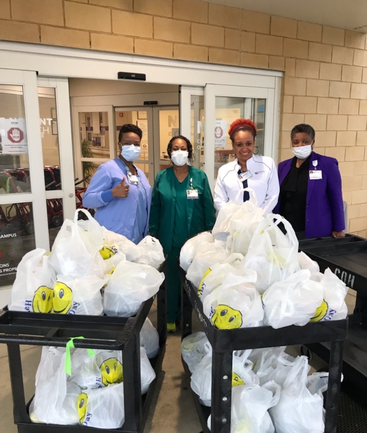 Healthcare workers receive cart of food