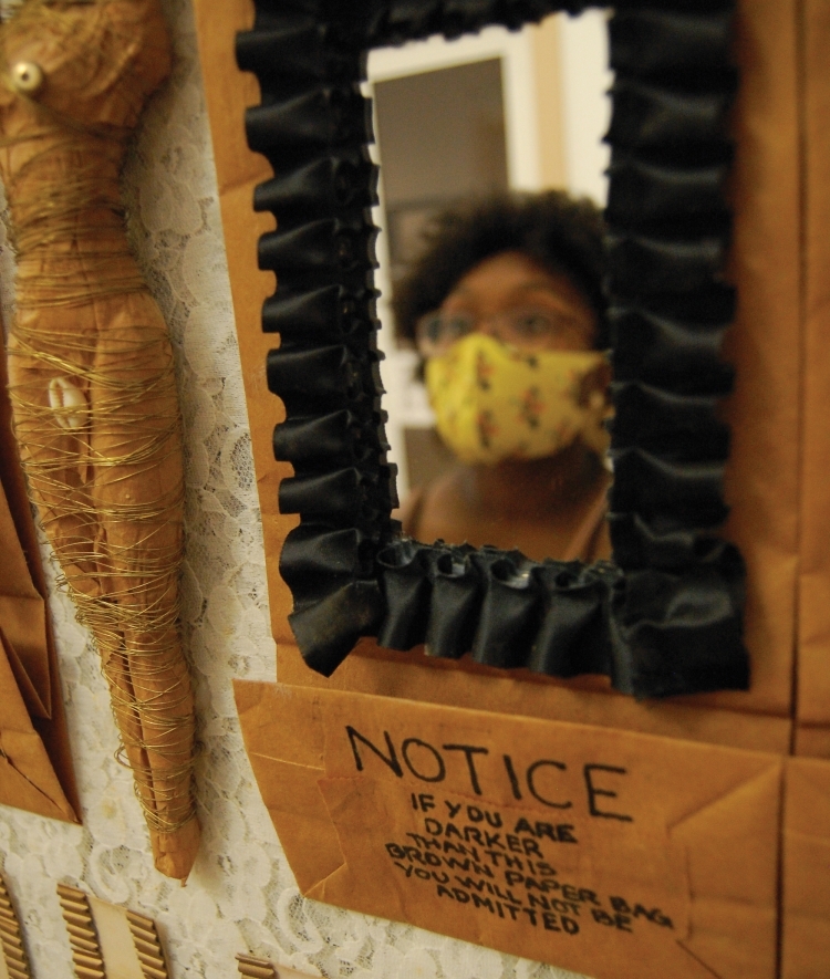 Student Reflected in Art Work Wearing Mask