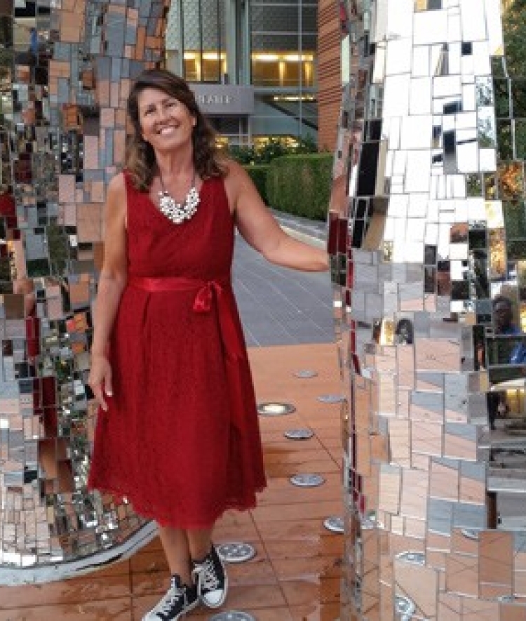 Davidson alumna, Jill Marcus ’86, Owner of Something Classic and The Mother Earth Group poses uptown with sculpture