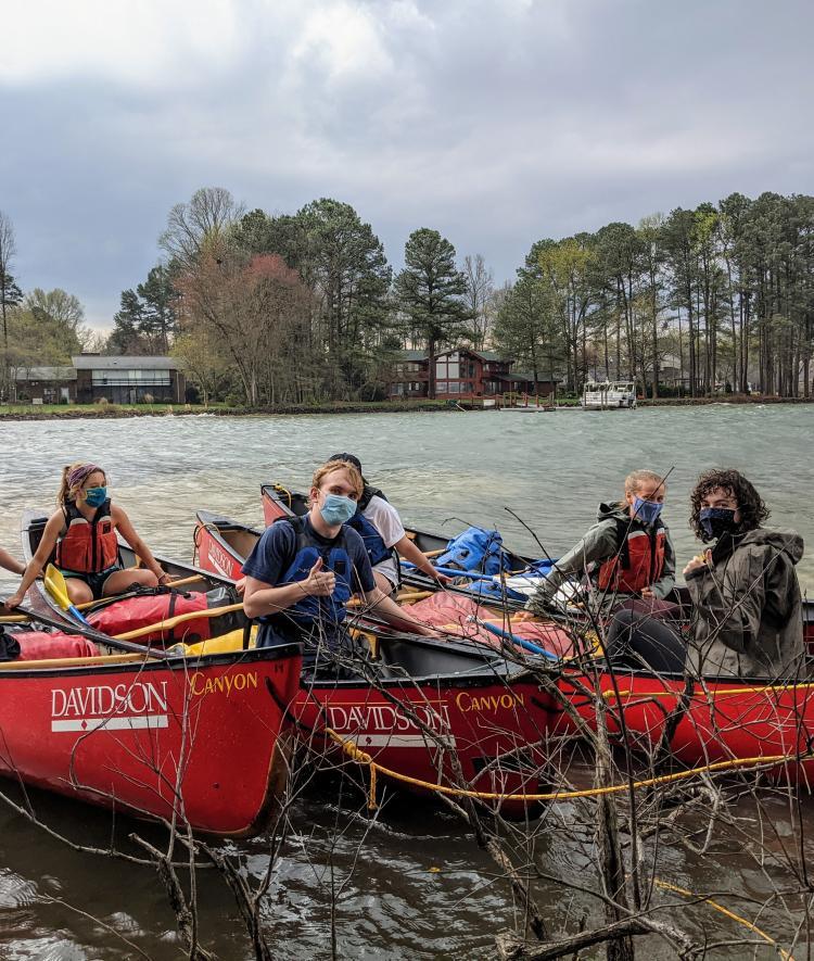 Students with Masks on Canoes on Lake Campus