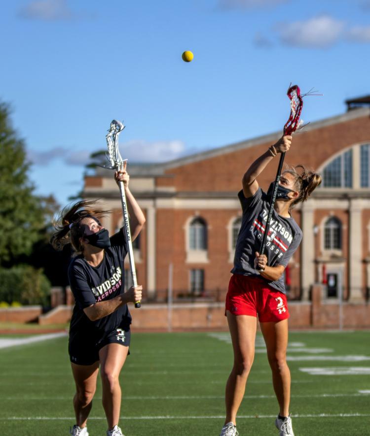 Lacrosse Students in Gear and Masks in Field