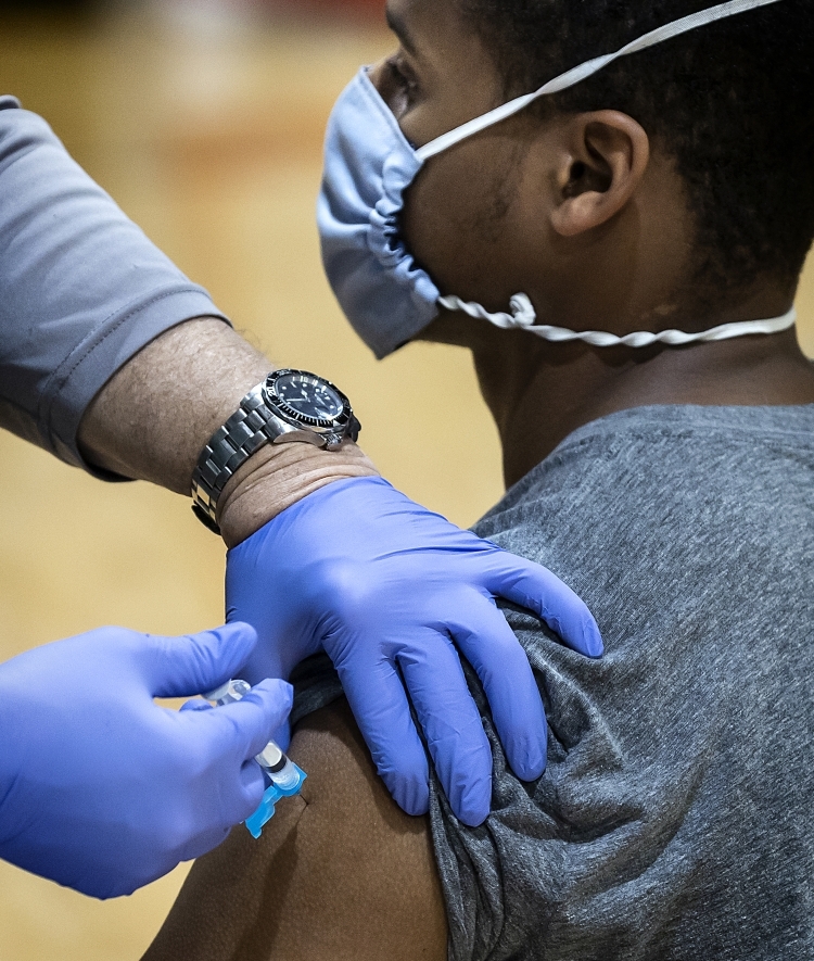 Student in Mask Being Vaccinated