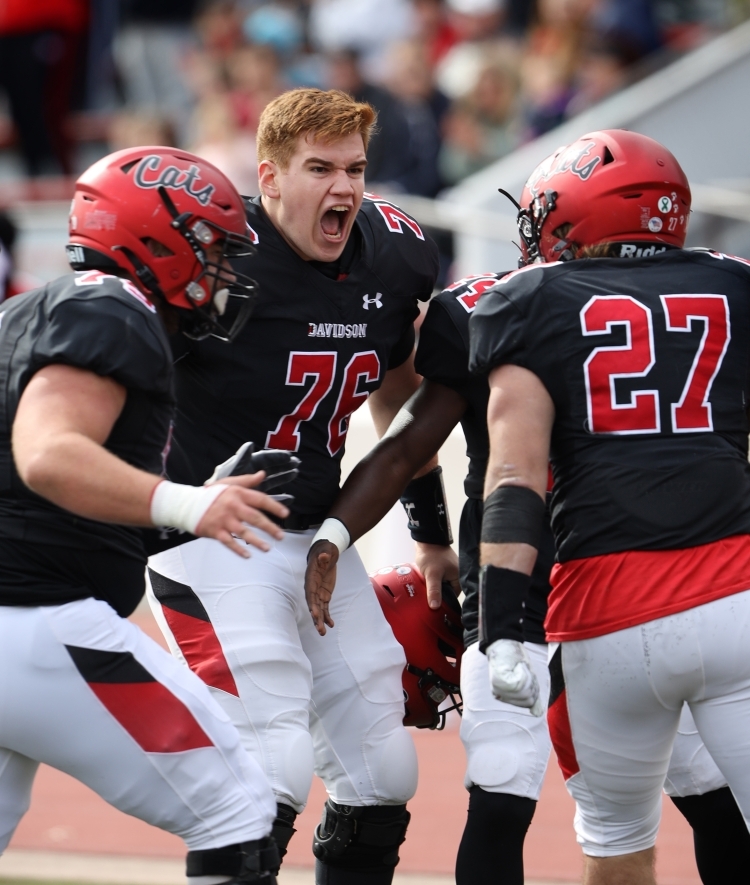 Football Player at Yelling Surrounded by Teammates in Helmets