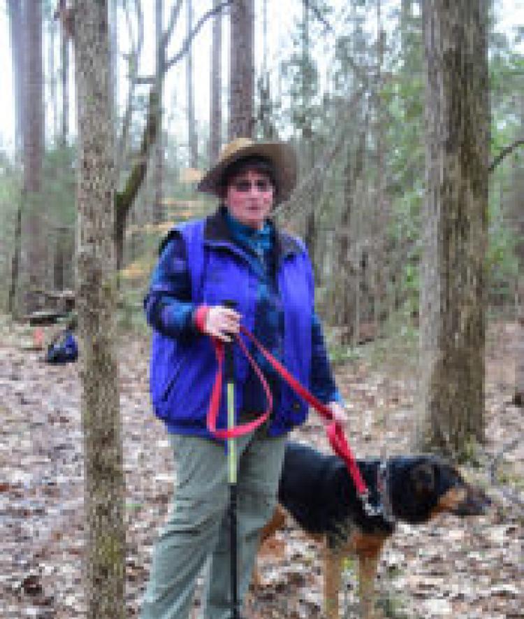 Davidson College Biology Professor Pat Peroni in the woods with her dog