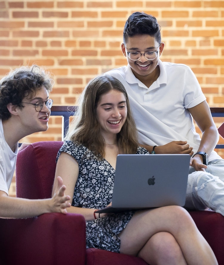 Group of students around laptop
