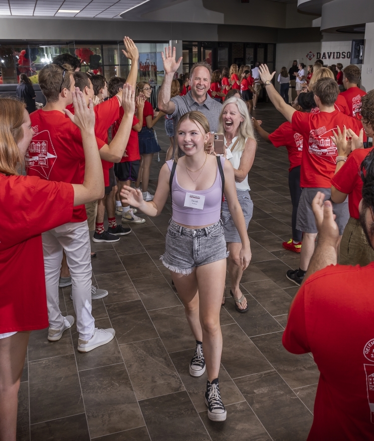 student and family walking through welcome tunnel during Orientation