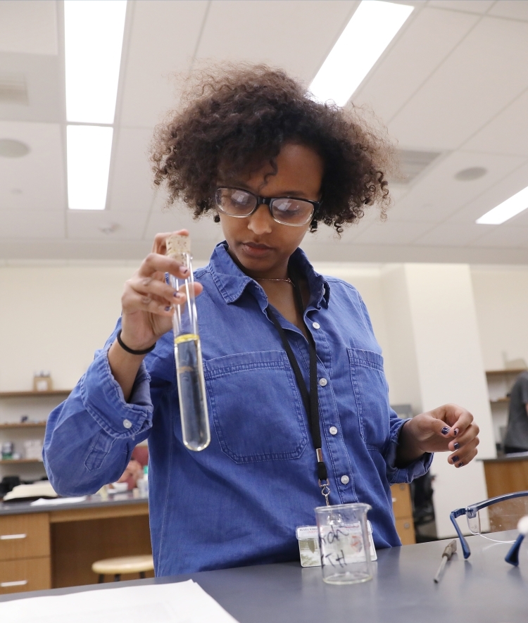 Student in chemistry lab holding test tube