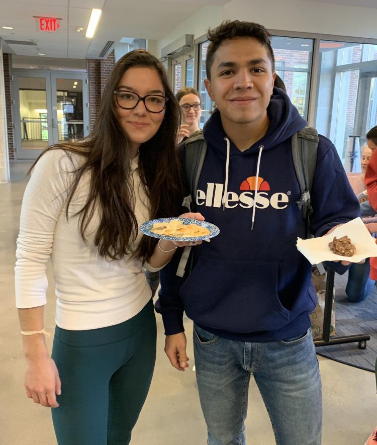 Students smiling holding cookies