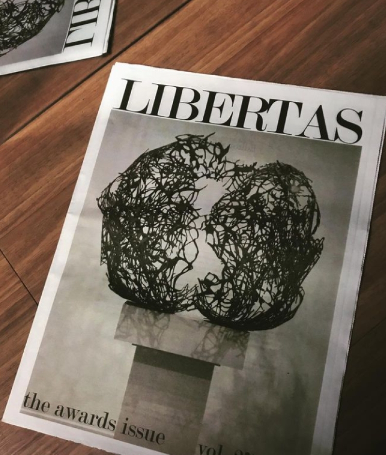 Magazines with art and "LIBERTAS" on cover
