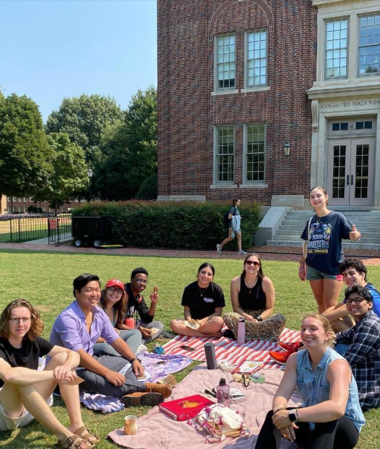 Students sitting on picnic blankets eating and smiling
