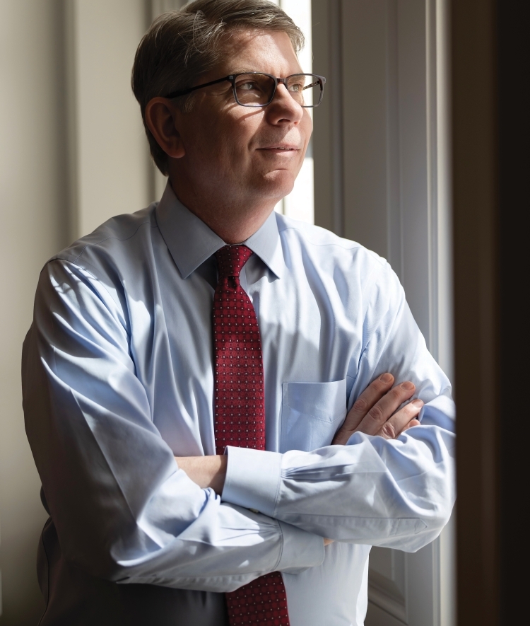 Photo of Doug Hicks in his office standing by a window