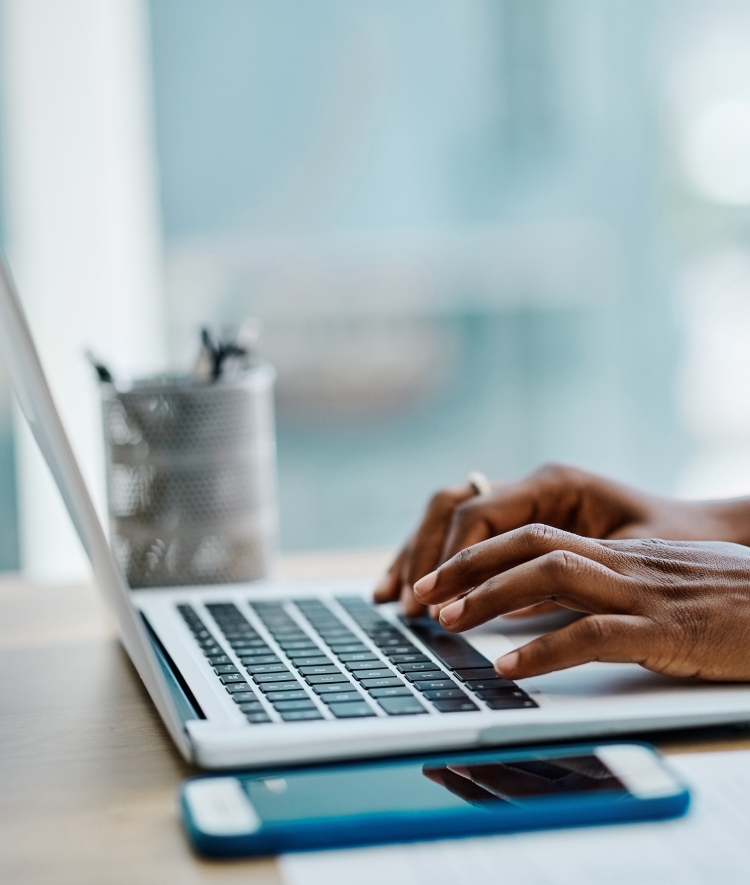 a set of hands on a laptop typing