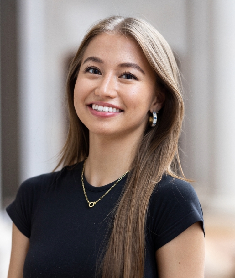 a young Asian woman wearing a black top and smiling