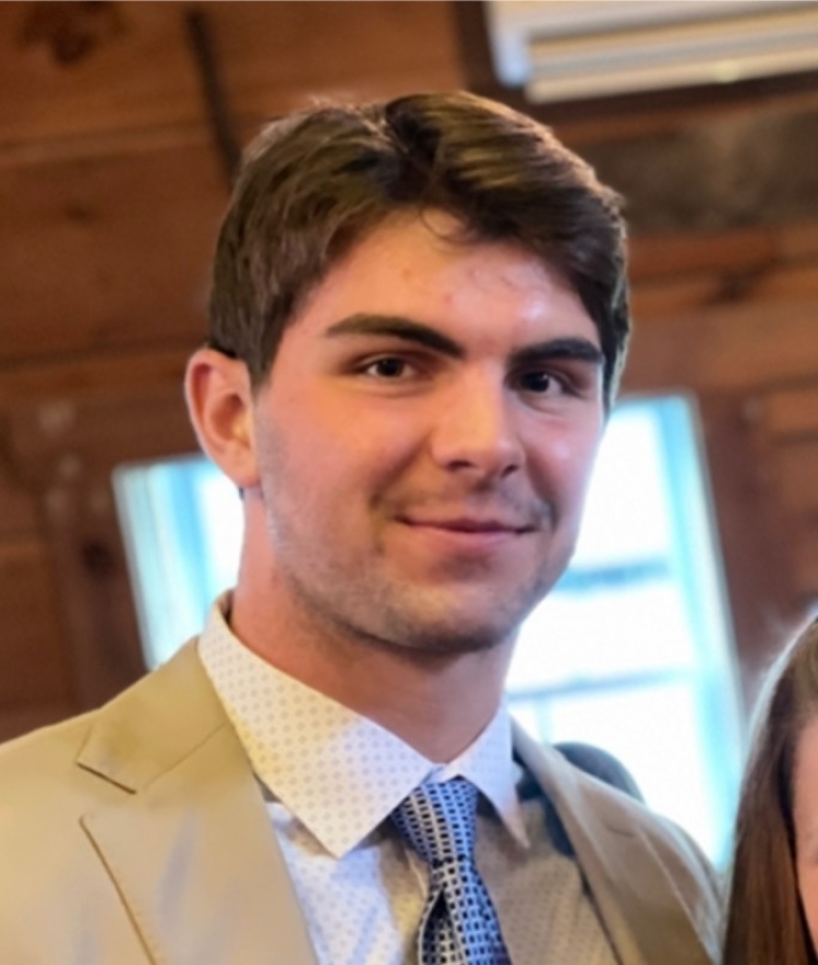 a young white man wearing a jacket and tie while smiling