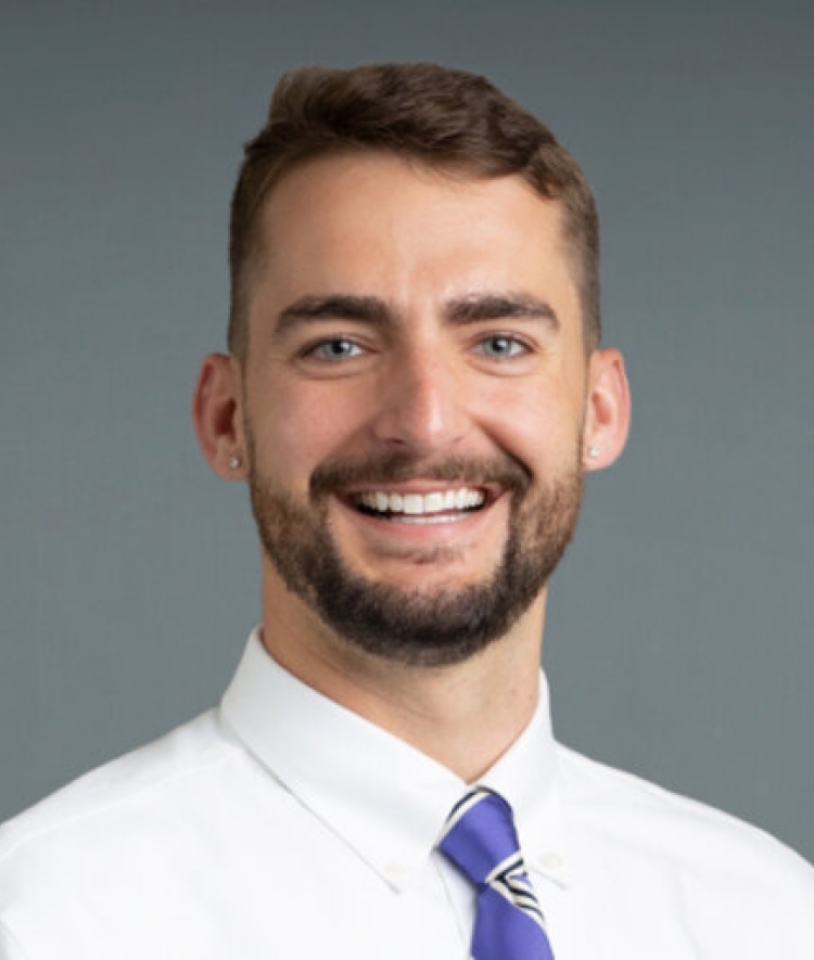 a young white man with a tie smiling