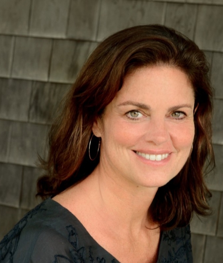 a middle aged woman with brown hair wearing a dark top