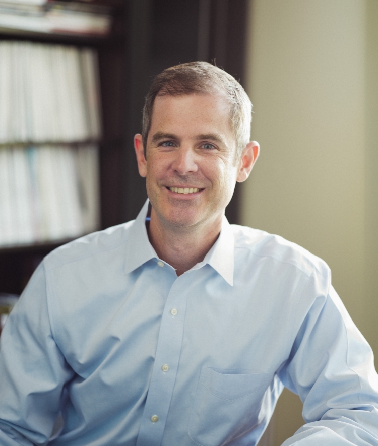 a middle aged white man wearing a light blue collared shirt