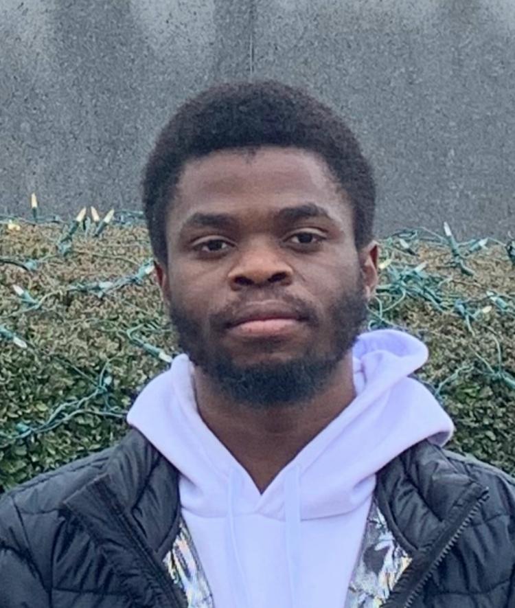a young Black male wearing a sweatshirt and jacket