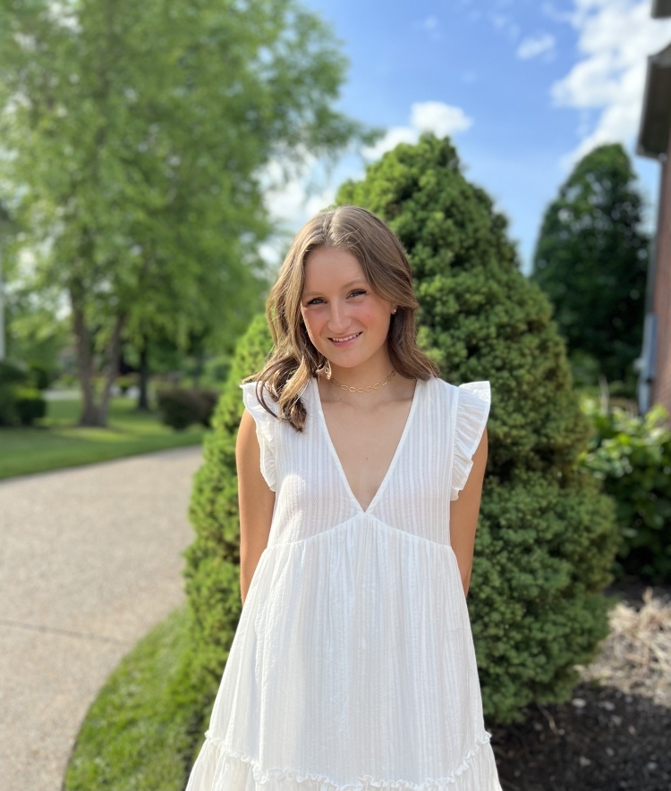 a young white woman wearing a white dress and smiling