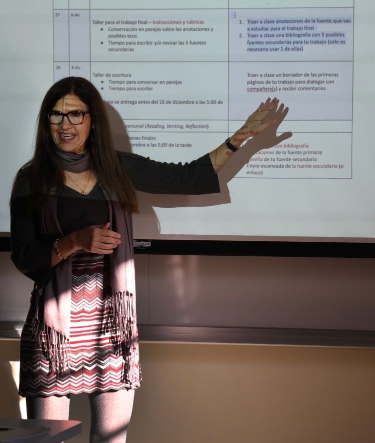 a woman stands in front of a screen while teaching