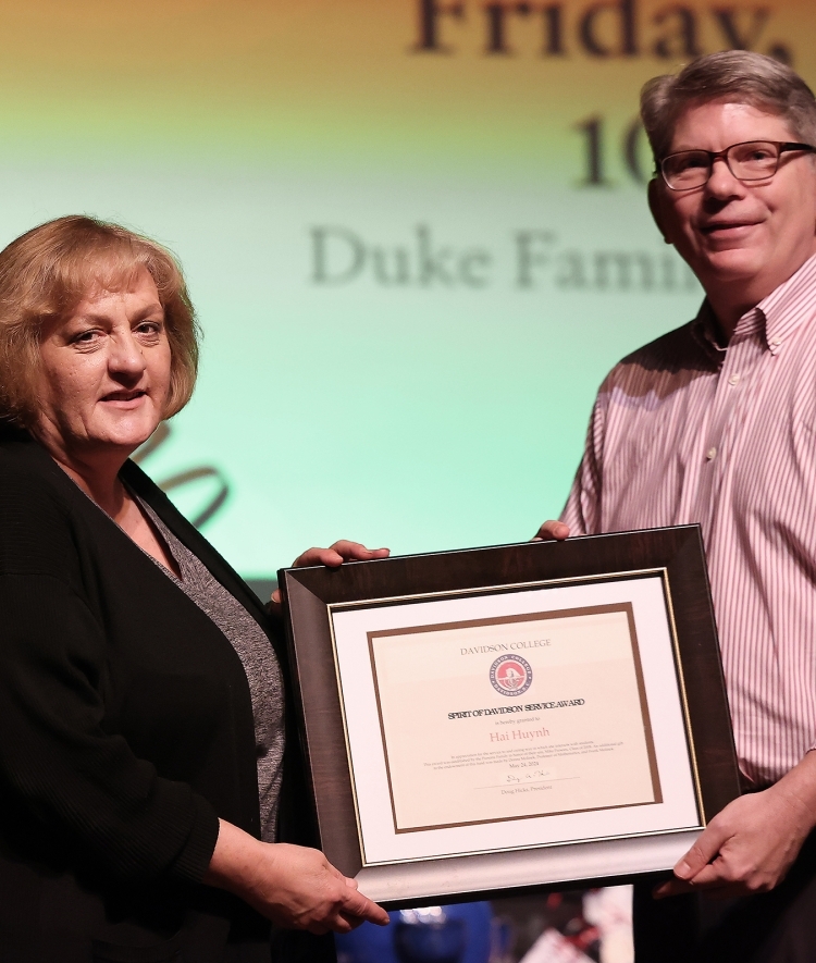 an older white woman and an older white man hold an award