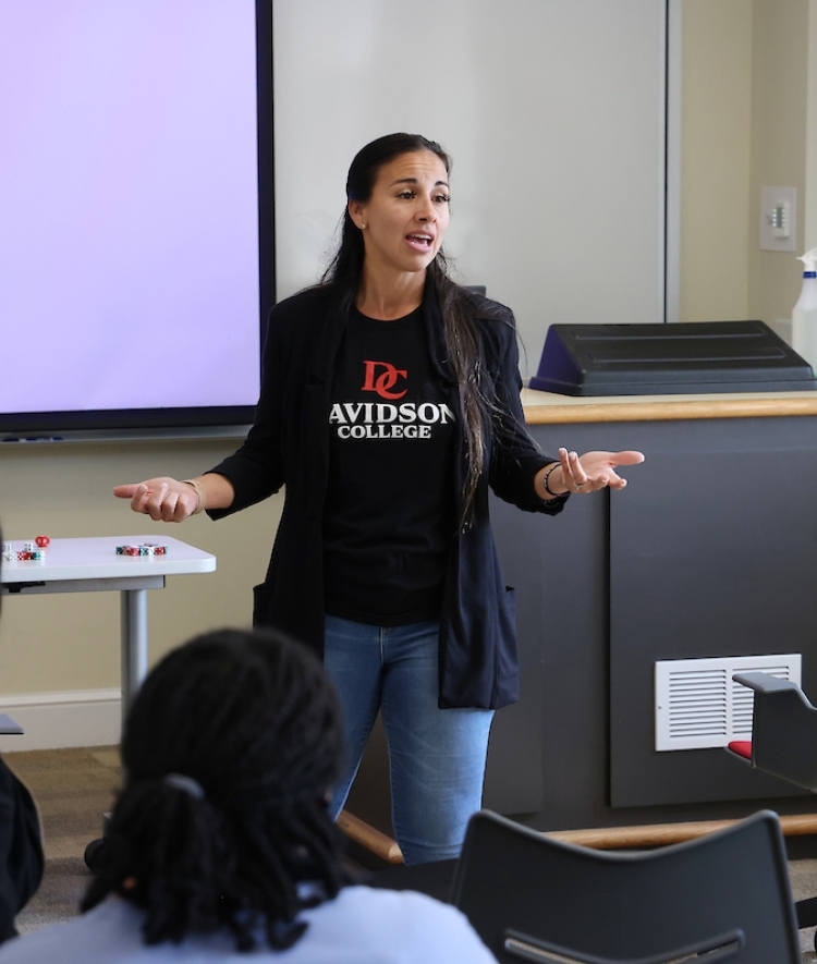 Professor speaks to students at the front of classroom