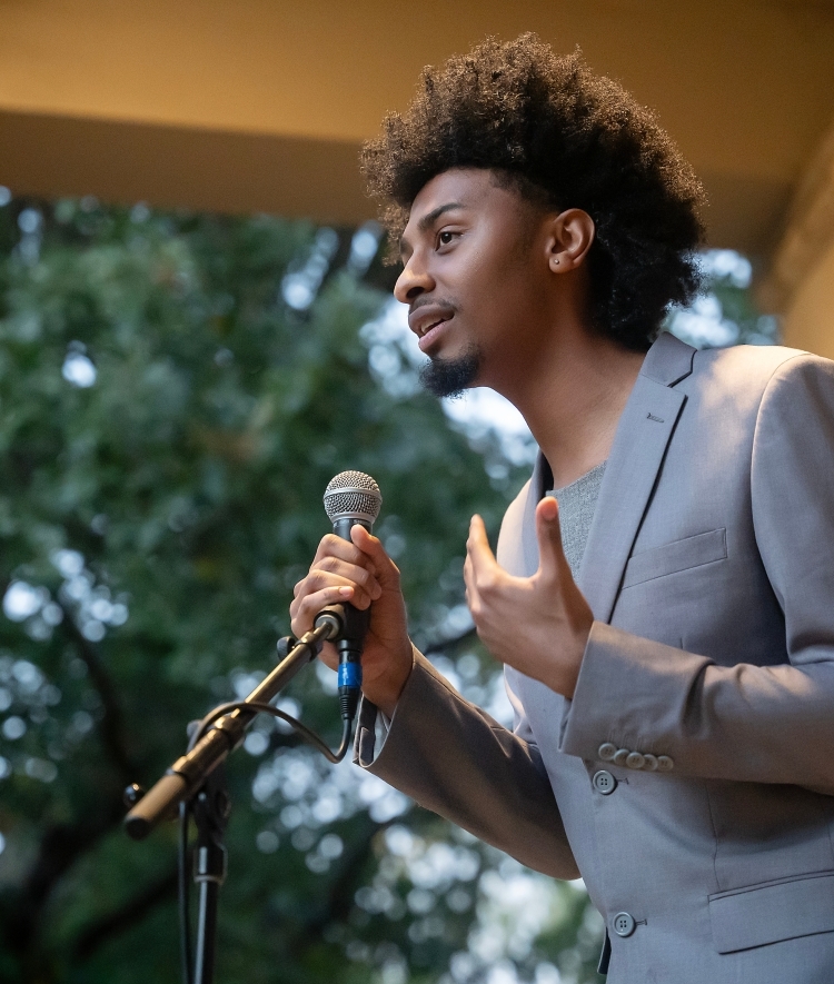 Student speaking at a microphone at the Phi Eu Debate