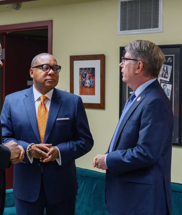 a group of men stand together talking