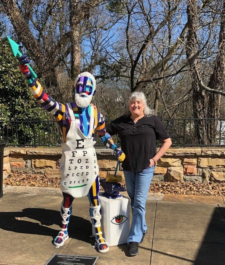 a woman poses with a state in a park