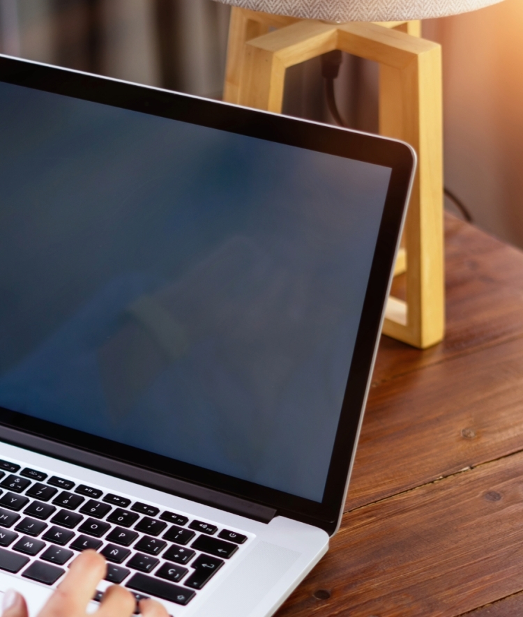a person working on a laptop with a notebook to the side