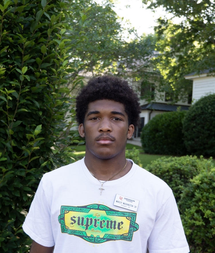a young Black man wearing a tshirt on a sunny morning