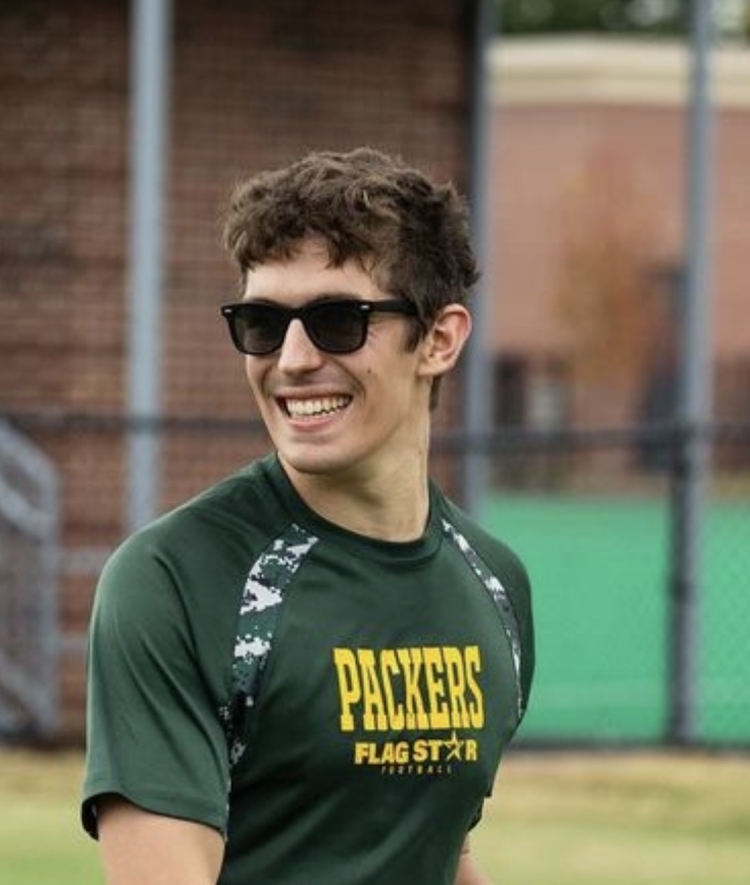 a young white man throws a frisbee