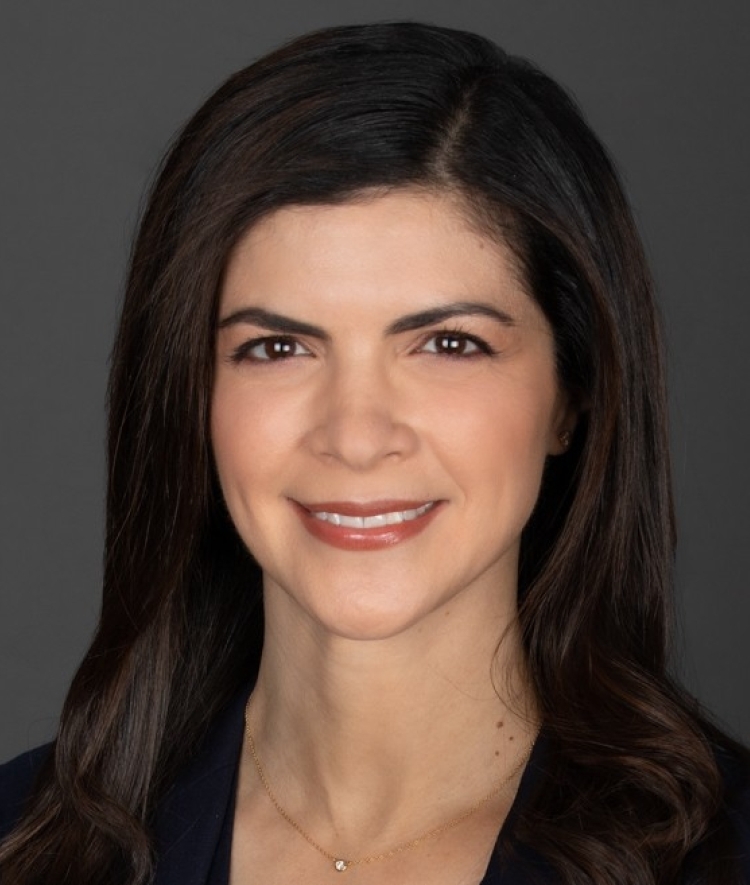 a young white woman with dark brown hair wearing a dark blazer