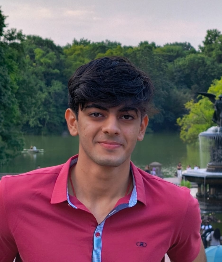 a young man with short dark hair wearing a collared shirt 