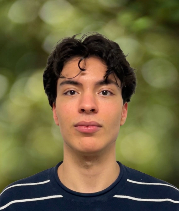 a young man with curly dark hair wearing a striped top