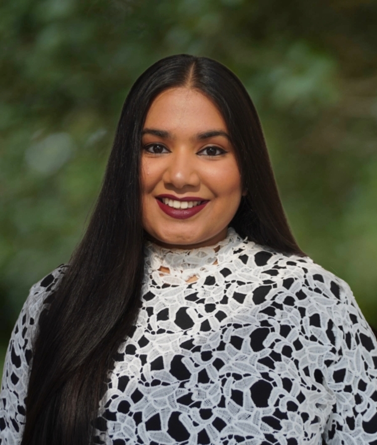 a young woman with long dark hair wearing a white and black crocheted top