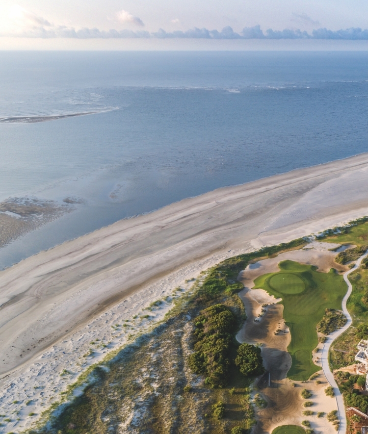 an aerial view of a beach and ocean in the distance