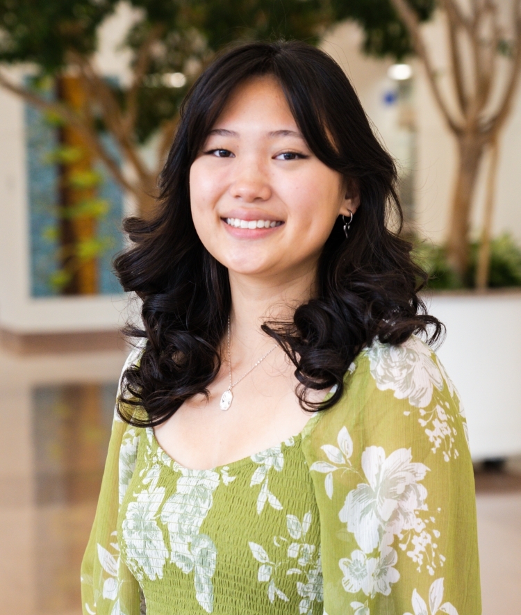 a young woman with curly dark hair smiling