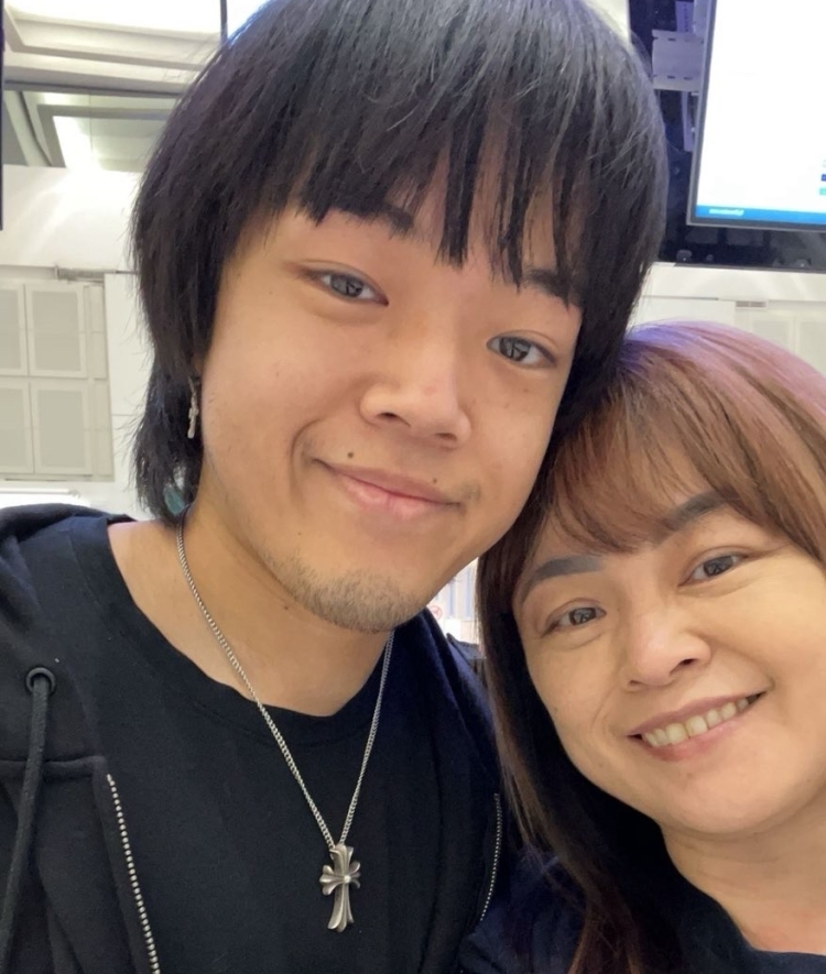a young man smiles with his mom
