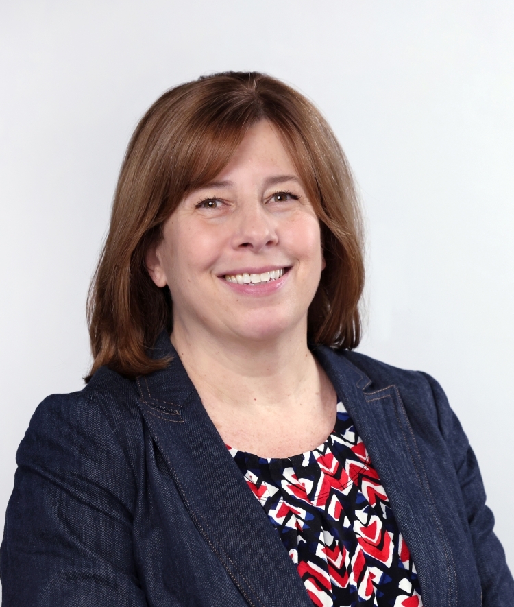 a woman with short brown hair wearing a red blouse and blue blazer