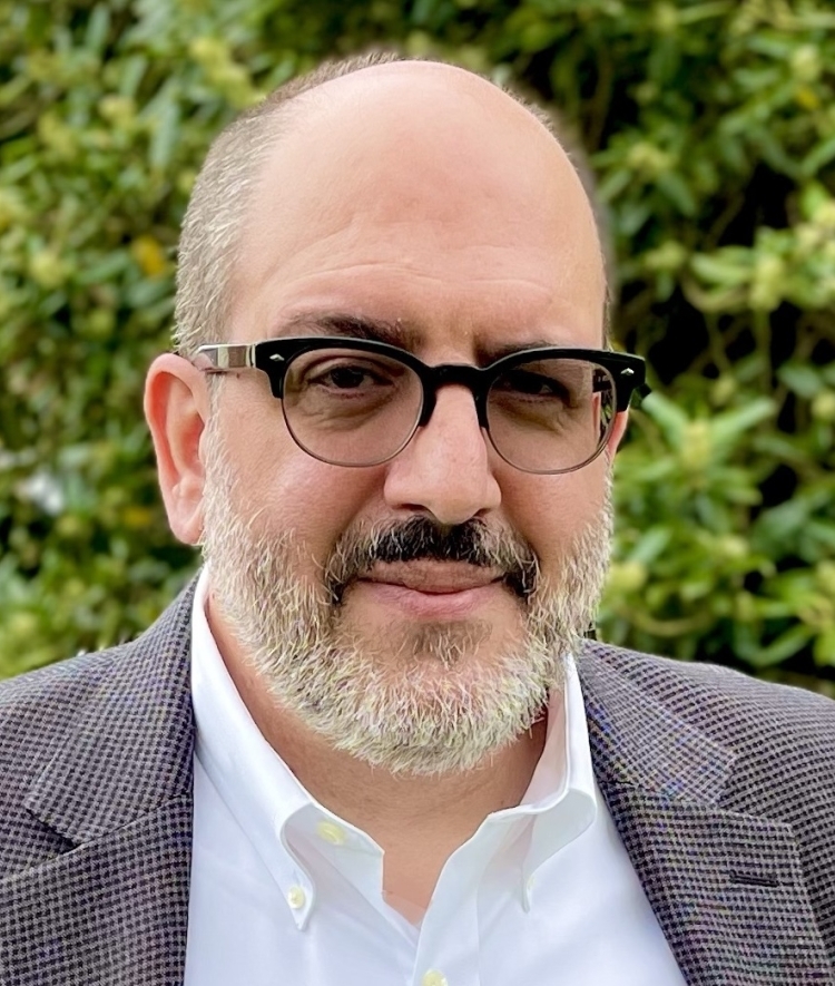 a professor wearing a white shirt and jacket with glasses