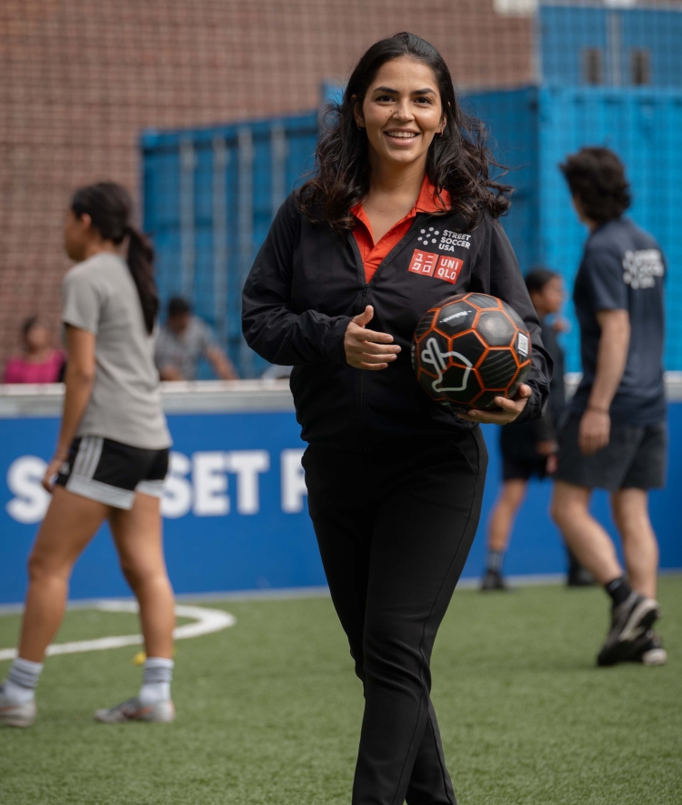 A female coach holds a soccer ball