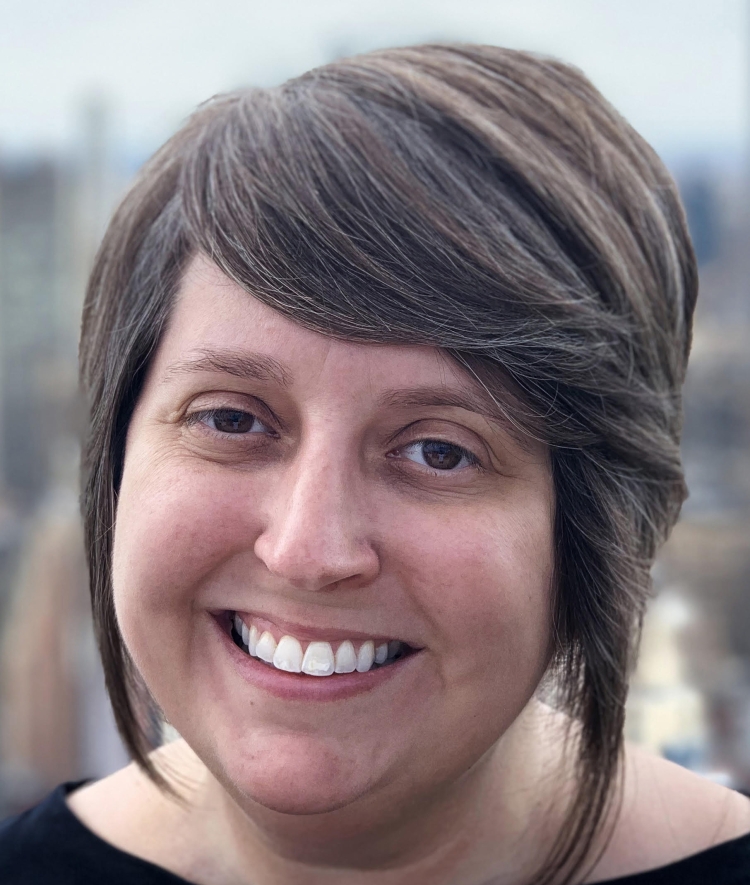An adult woman with a brown bob, brown eyes, and side-swept bangs
