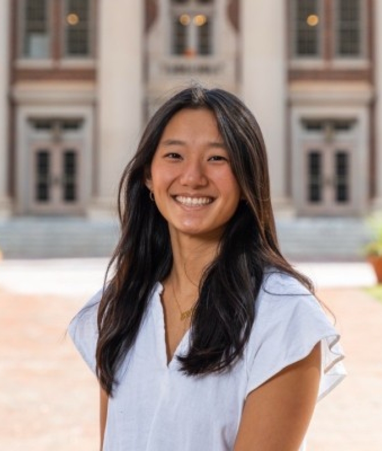 a headshot of Holly Beale in front of Chambers Building on a sunny day
