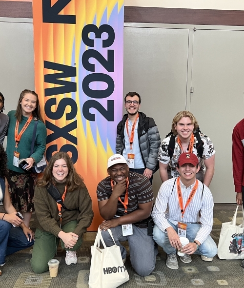 Group of students standing in front of a sign that says "SXSW"