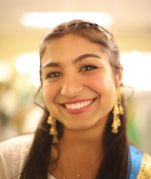 A young woman with black hair smiling at the camera 