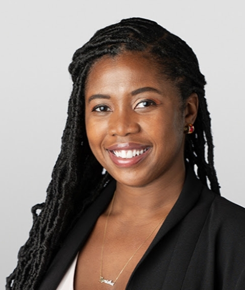 a young Black woman wearing a black blazer and smiling